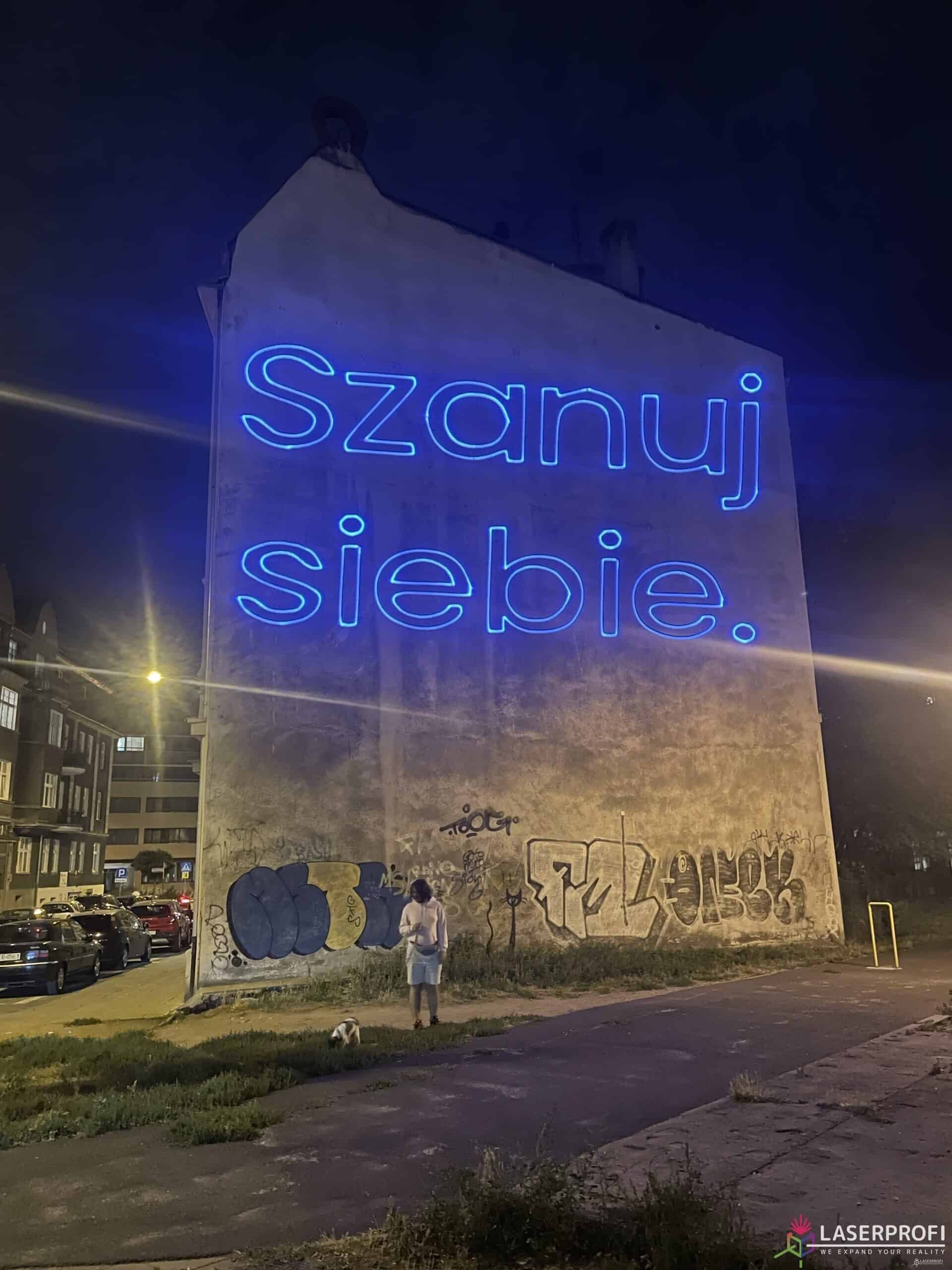 Reklama laserowa na budynku - slogan szanuj siebie Poznań